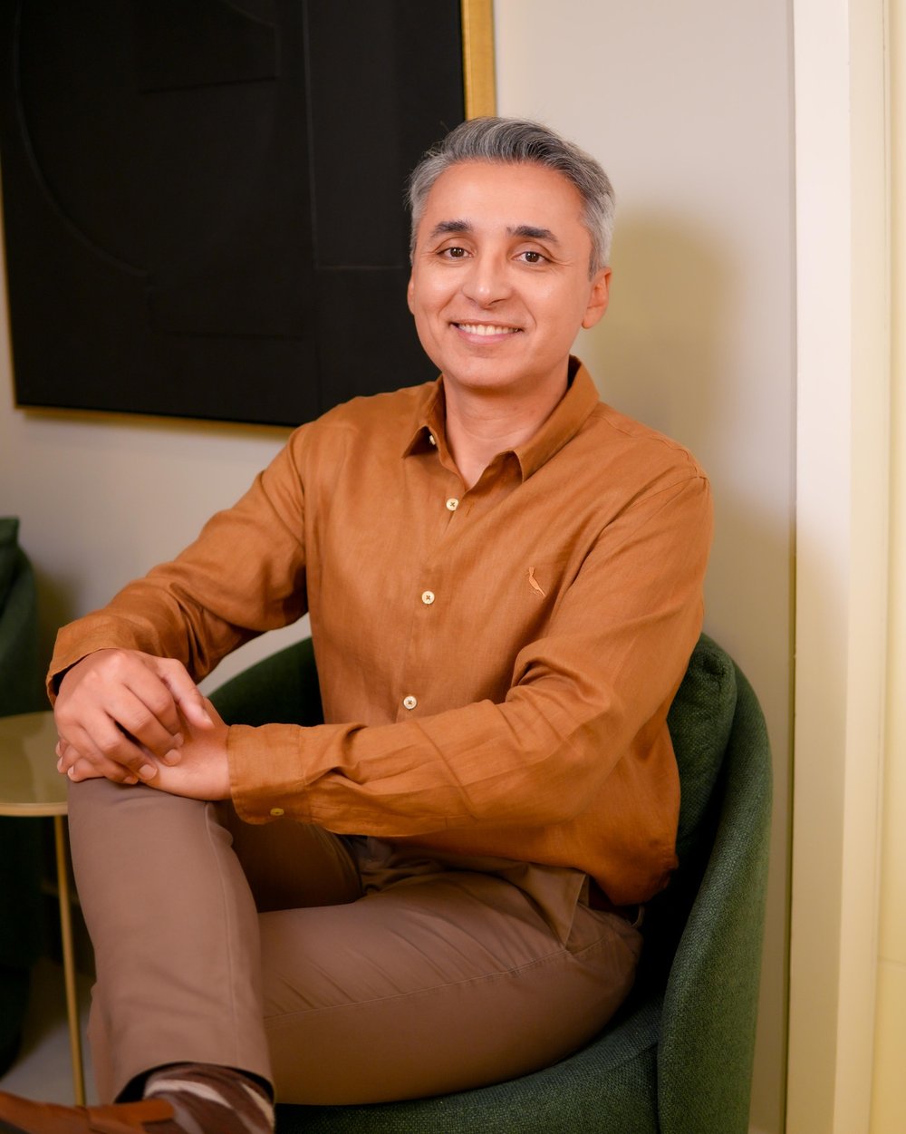 Dr. Euler Amaral em pé no consultório, vestindo camisa verde-oliva